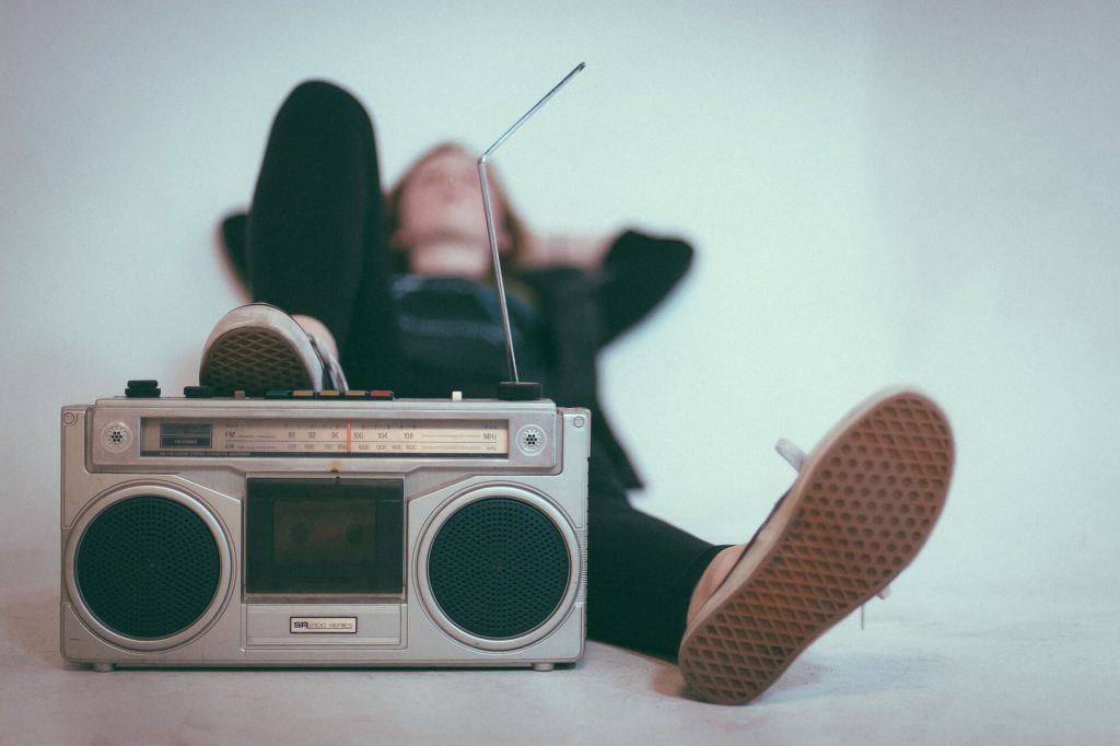 A person in a relaxed position, with one foot resting on top of a radio, enjoying a moment of relaxation.